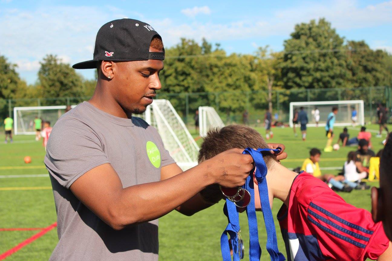 Member of the team putting a medal on a boy